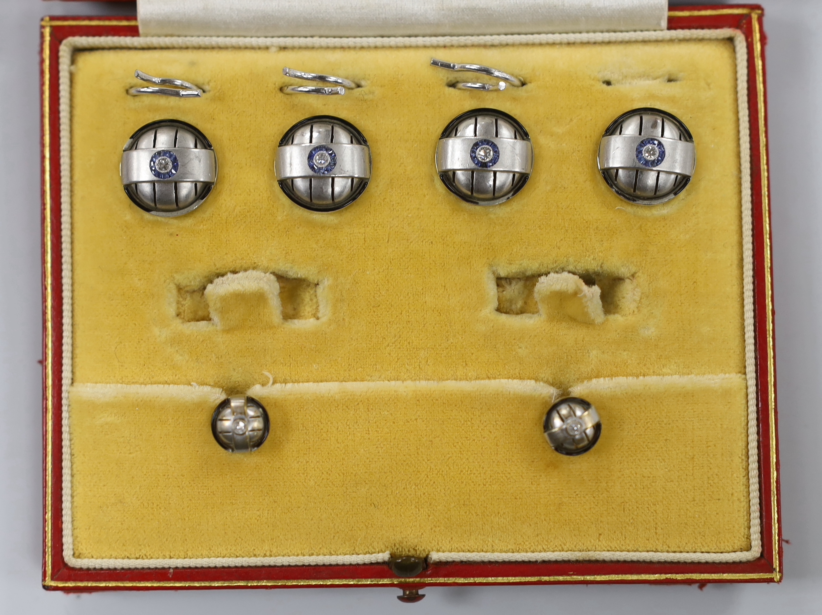 A white metal, sapphire and diamond chip cluster four piece part dress stud set, lacking cufflinks.